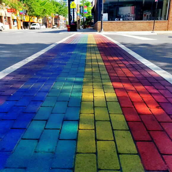 Street crosswalk made of bricks painted in Pride colours